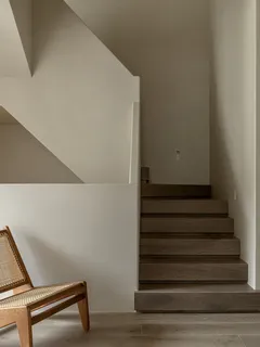 Treppenhaus mit einem einzelnen Stuhl an der Wand