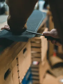 Person schneidet Holzstück mit Schere