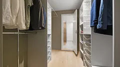 Begehbarer Kleiderschrank voller Kleidung und Accessoires