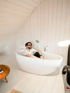 Mann entspannt im weißen Bad mit klarem Wasser