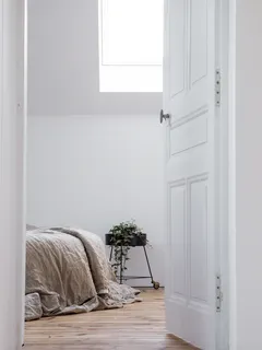 Weißes Bettwäsche-Set auf Bett in hellem Schlafzimmer