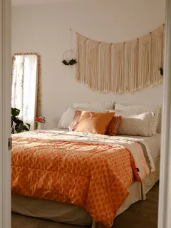 Boho Schlafzimmer mit Sonnenlicht und gelbem Bettbezug